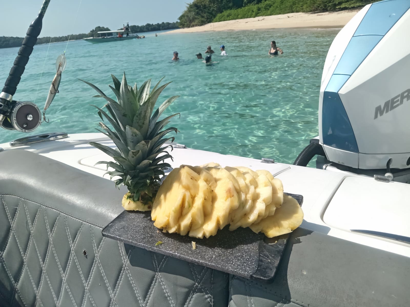 Piña cortada a bordo frente a una playa de isla en Panamá