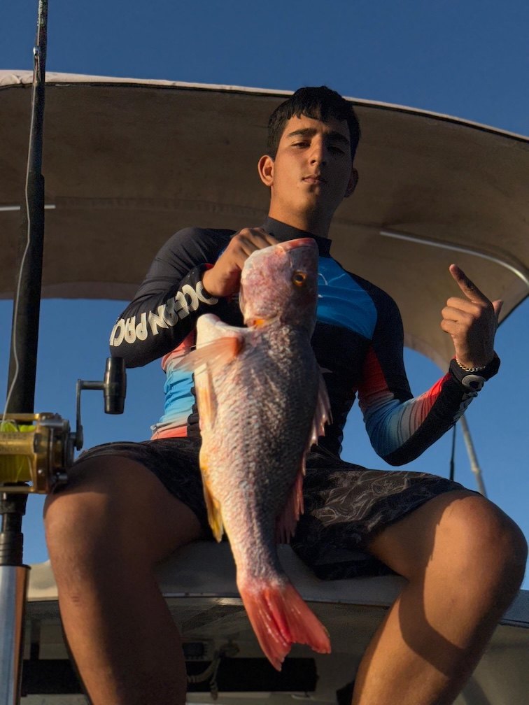 Angler seated with a fish on board
