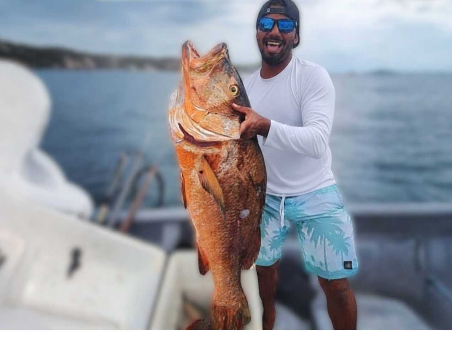 Guest holding a trophy fish on board